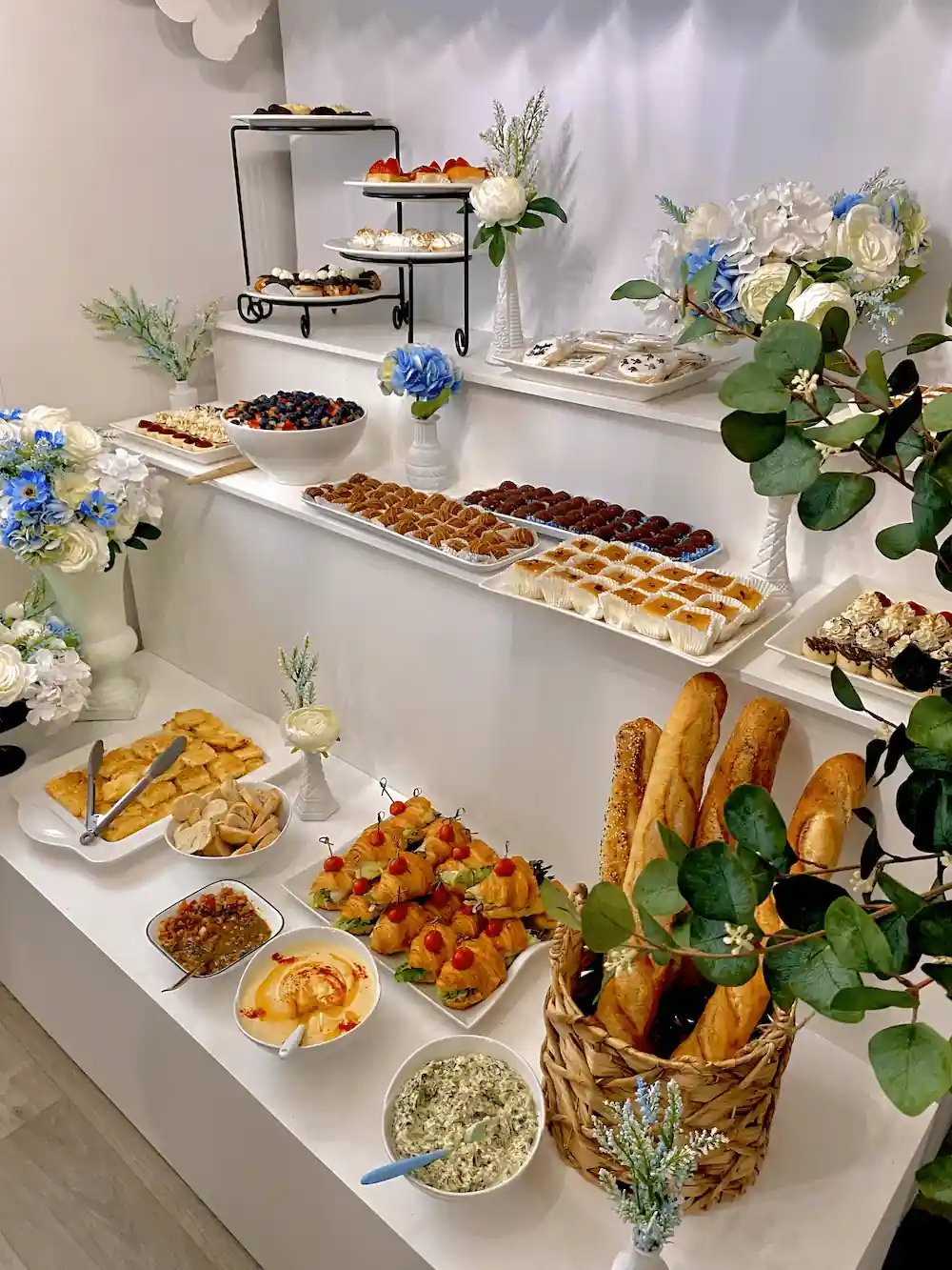 An exquisite Parisian-inspired dessert buffet featuring an assortment of pastries, tarts, chocolate truffles, and fruit platters, beautifully arranged with elegant floral decorations and candlelit ambiance.        